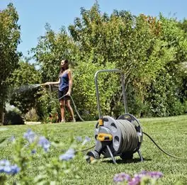 Bęben na kółkach na 60 m węża 2398 OO-HOZ2398 podczas pracy w ogrodzie